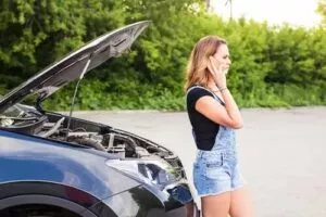 young woman with broken down car